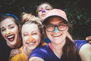 Friends gathered under the sun with colorful spf protecting their noses